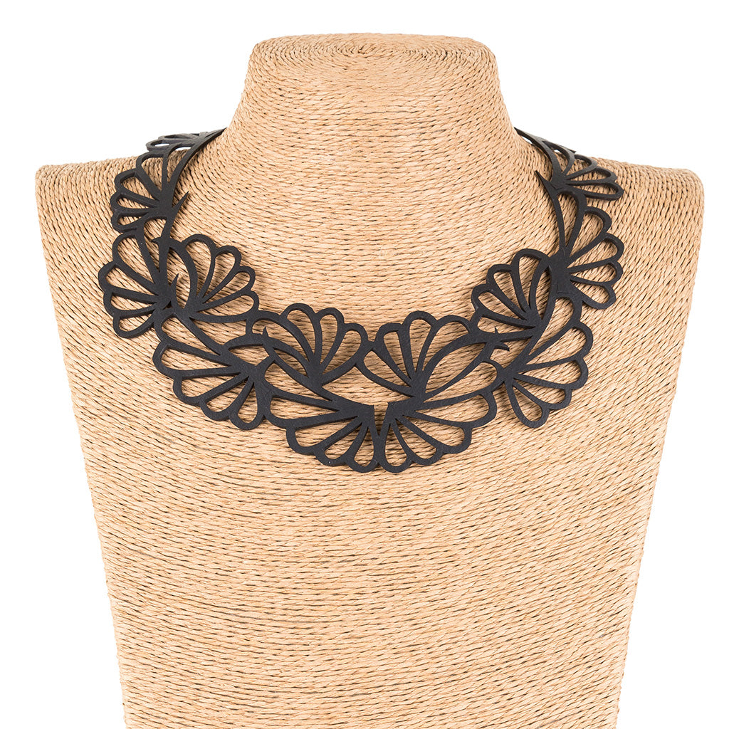 Paguro Upcycle black floral statement necklace displayed on straw mannequin upcycled vegan flower necklace