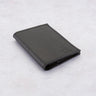 Black Paguro Upcycle recycled rubber wallet with textured surface folded on a light background