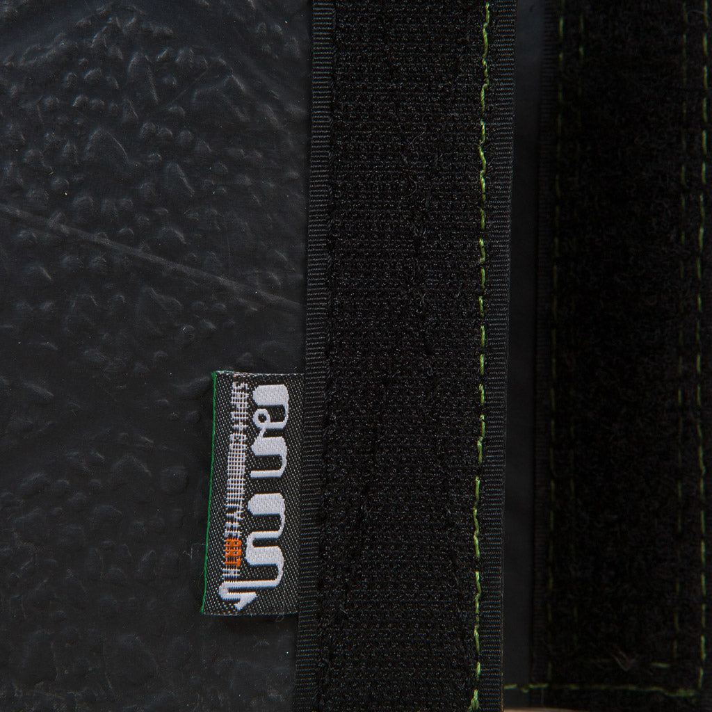 Close-up of Paguro Upcycle vegan recycled wallet showing black textured material and green stitched details