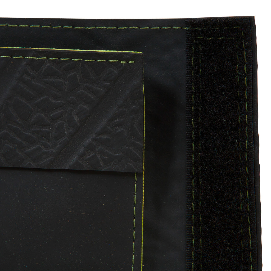 Close-up of black vegan recycled wallet by Paguro Upcycle with green stitching and textured detail