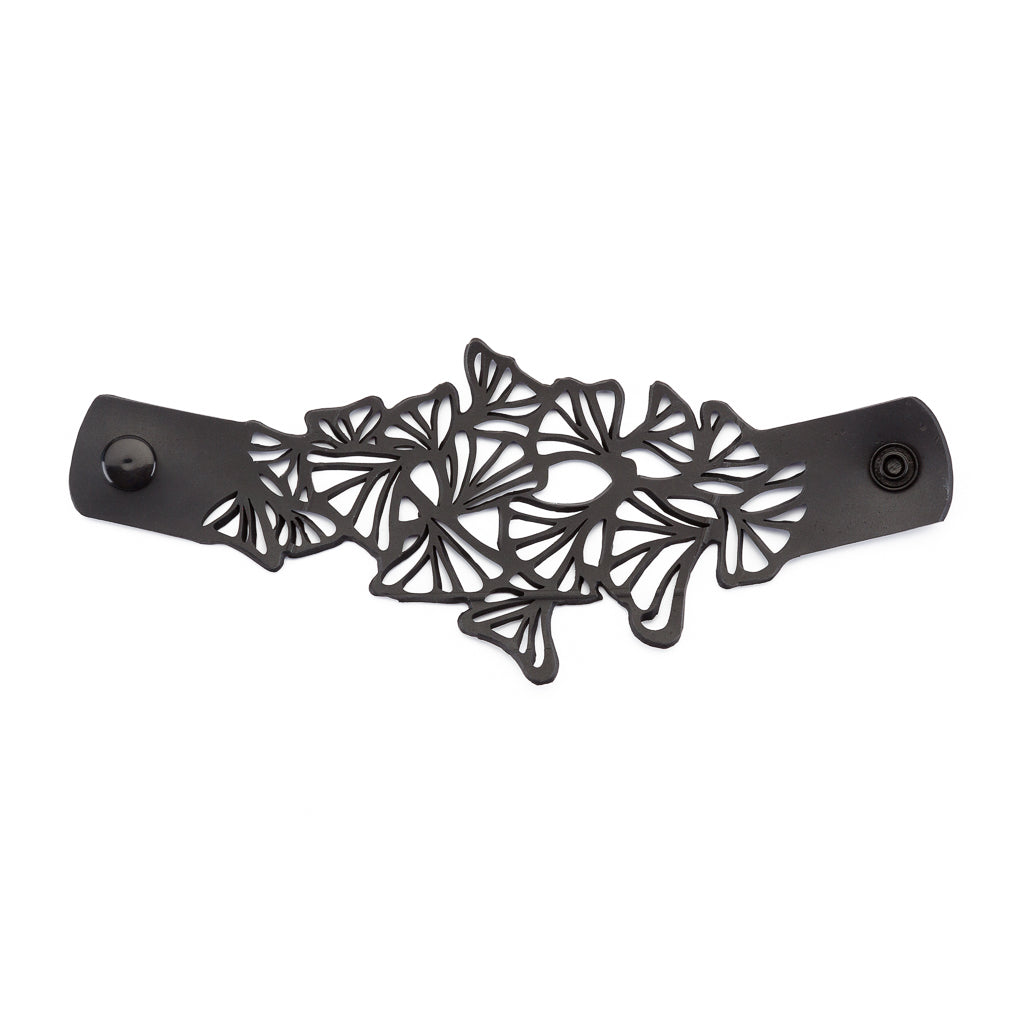 Paguro Upcycle black upcycled rubber bracelet with intricate cutout clover leaf design and snap closure