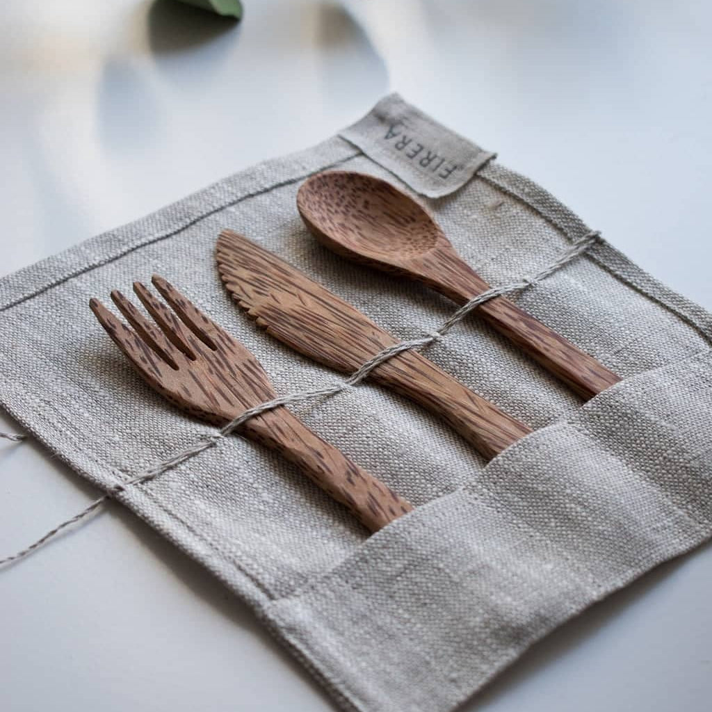 Eco-friendly bamboo utensils arranged in a linen pouch for a sustainable living guide