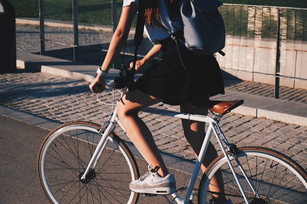 Sustainable travel tips featuring a cyclist in a city setting, promoting eco-friendly transportation methods