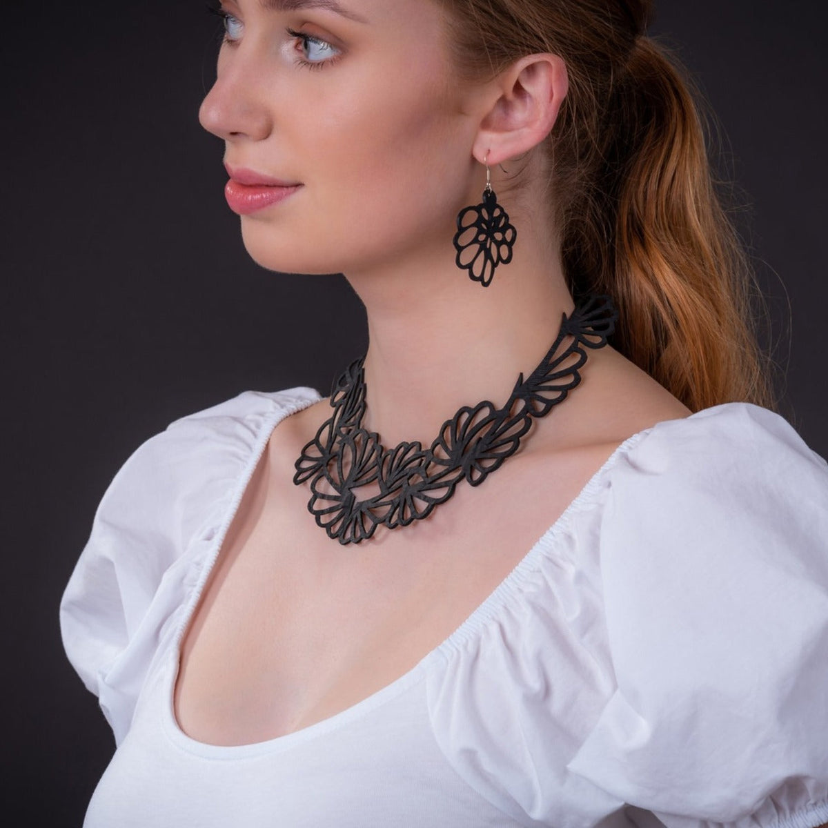 Model wearing the Violets upcycled flower statement necklace and matching earring from Paguro's Flower & Leaf Jewellery