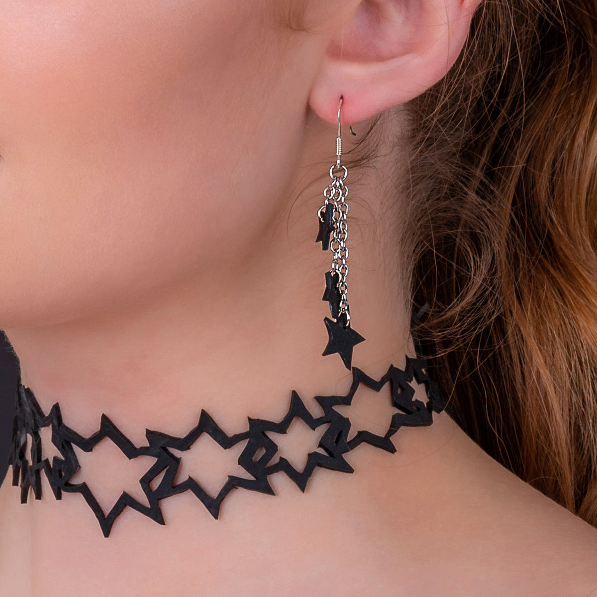 Model wearing the Stars recycled inner tube earrings from the Star Set