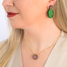 Paguro Upcycle reclaimed wood earrings shaped like green leaves worn on a woman with matching reclaimed wood necklace