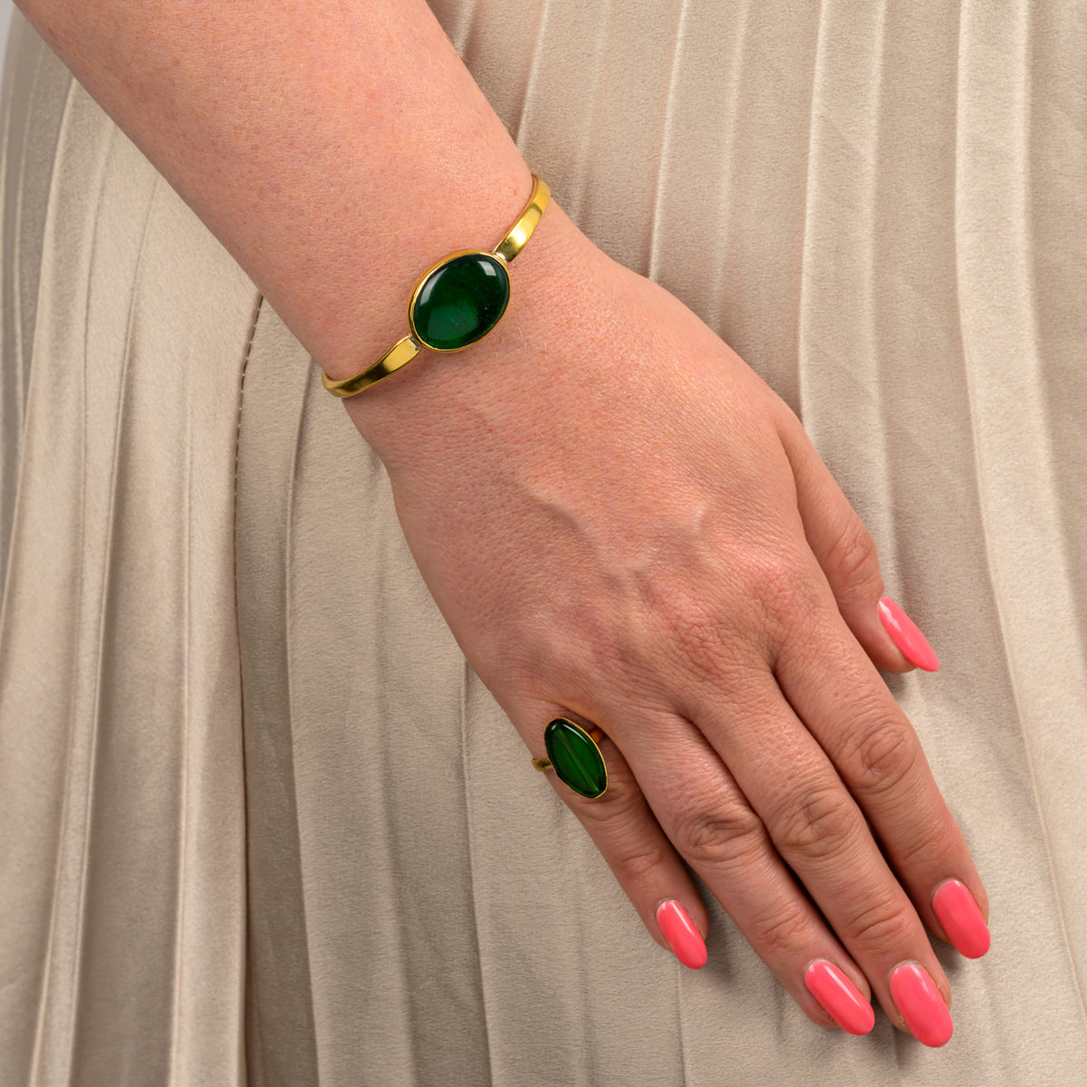 Paguro Upcycle recycled glass ring with green stone and matching bracelet on hand with pink nails