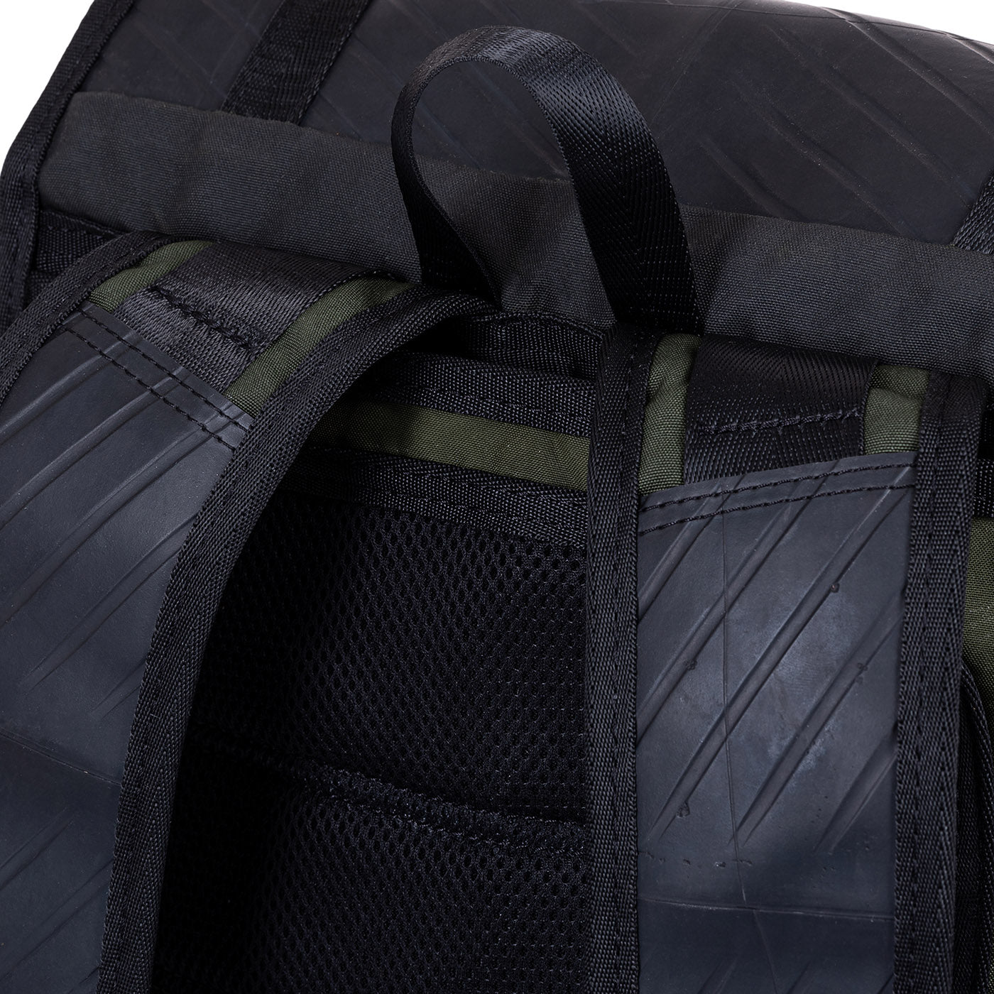 Close-up of a black and green backpack with textured details.