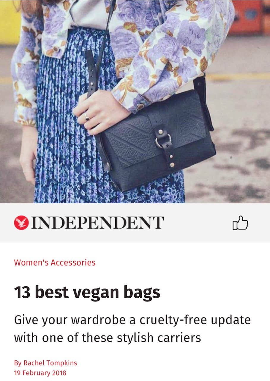 Black vegan handbag by Paguro Upcycle shown worn with floral blouse and blue patterned skirt