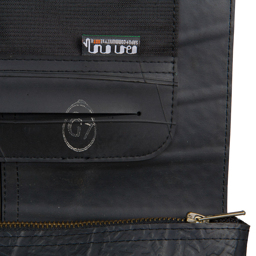 Close-up detail of Paguro Upcycle recycled rubber crossbody bag showing stitching and zipper
