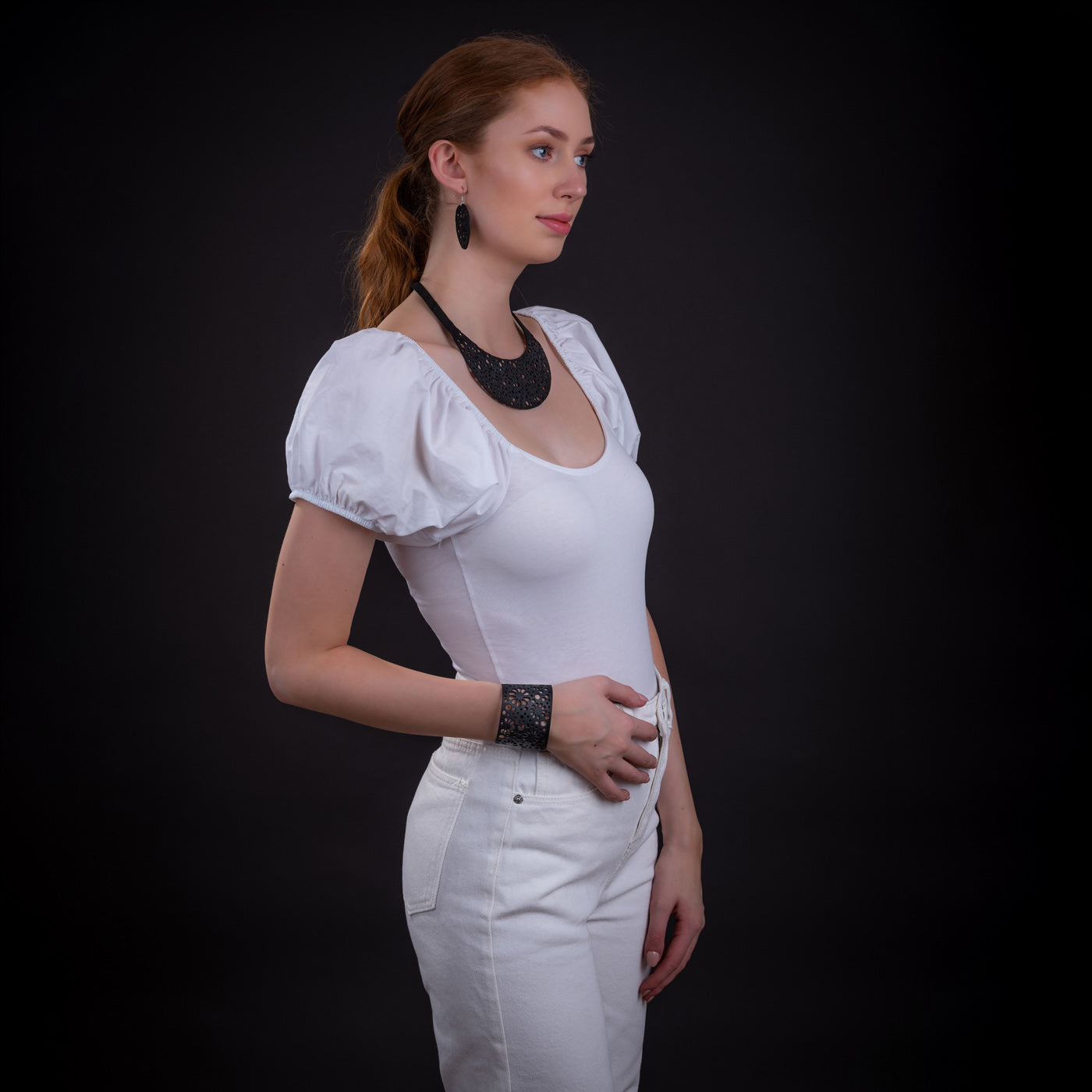 Paguro Upcycle black upcycled inner tube necklace on model wearing white top with matching cuff and earrings