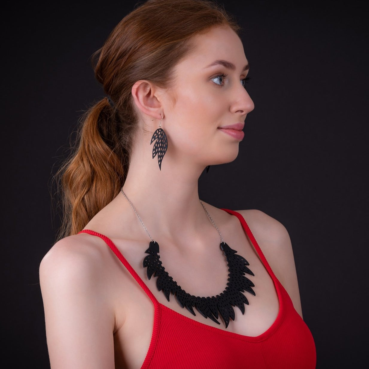 Paguro Upcycle model wearing black leaf recycled rubber earrings with matching statement necklace