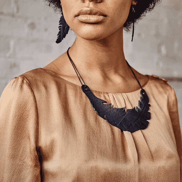Paguro Upcycle black upcycled feather necklace worn on model with beige blouse
