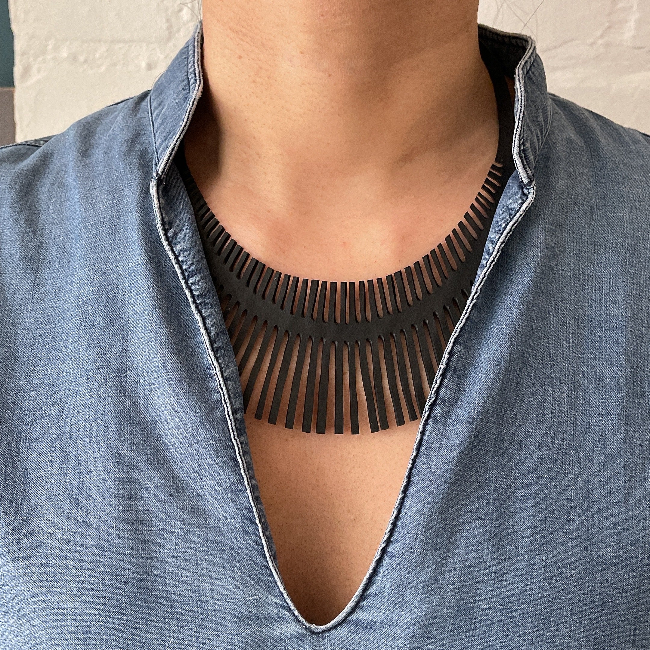 Paguro Upcycle upcycled inner tube necklace black fringe statement collar worn over denim shirt