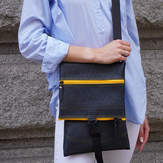 Paguro Upcycle recycled rubber crossbody bag in black with yellow zipper and adjustable strap