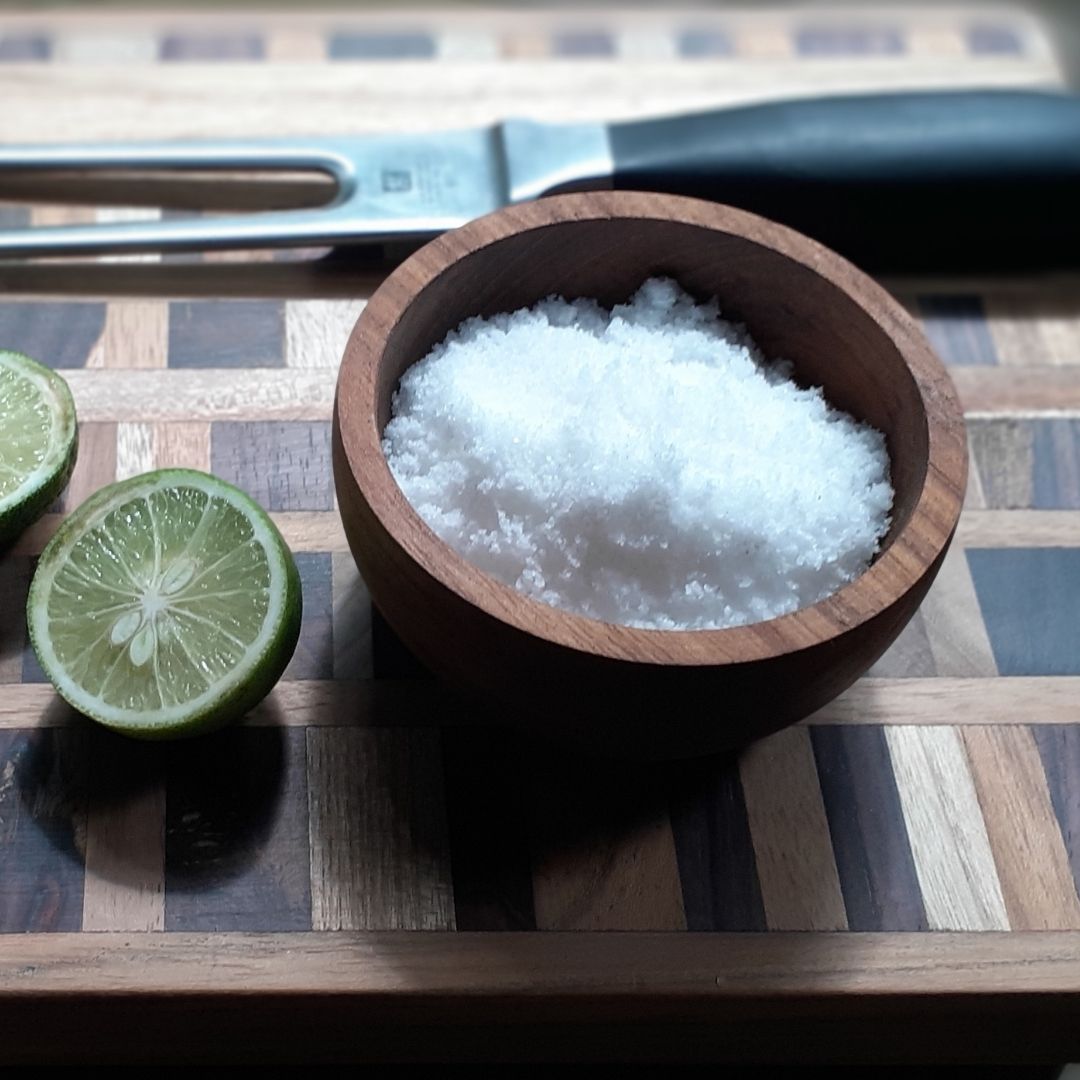 Paguro Upcycle upcycled wooden mini bowl filled with salt next to sliced lime on wooden cutting board
